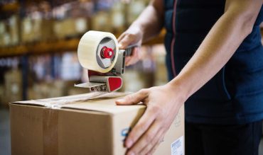 male-warehouse-worker-sealing-cardboard-boxes-PSKUTTE.jpg